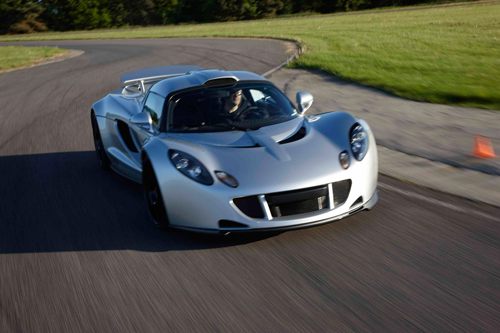"A photo of a Hennessey Venom GT sports car speeding along a winding road."