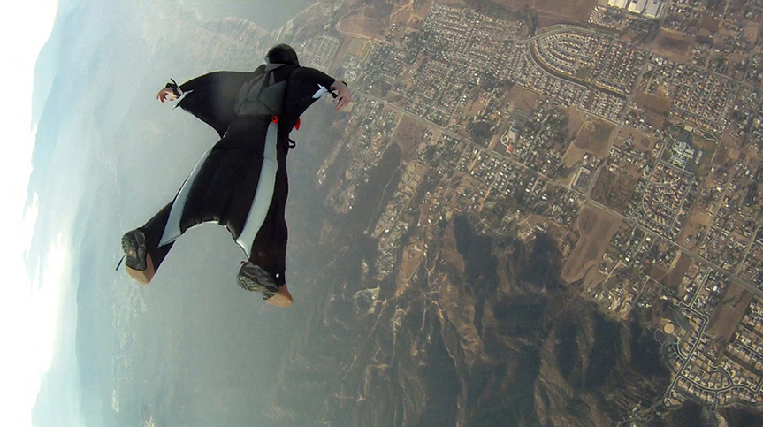 "A person falling in a wingsuit, which works to reduce the vertical velocity of a skydiver’s fall."